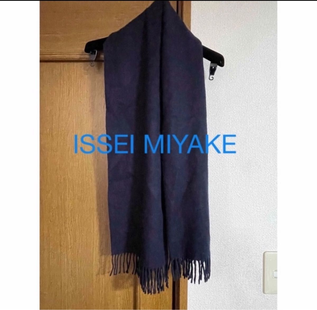 ダークブルーのISSEI MIYAKE製100%毛マフラー、フリンジ付きでスタイリッシュ。 ダークブルーのISSEI MIYAKE製100%毛マフラー、フリンジ付きでスタイリッシュ。