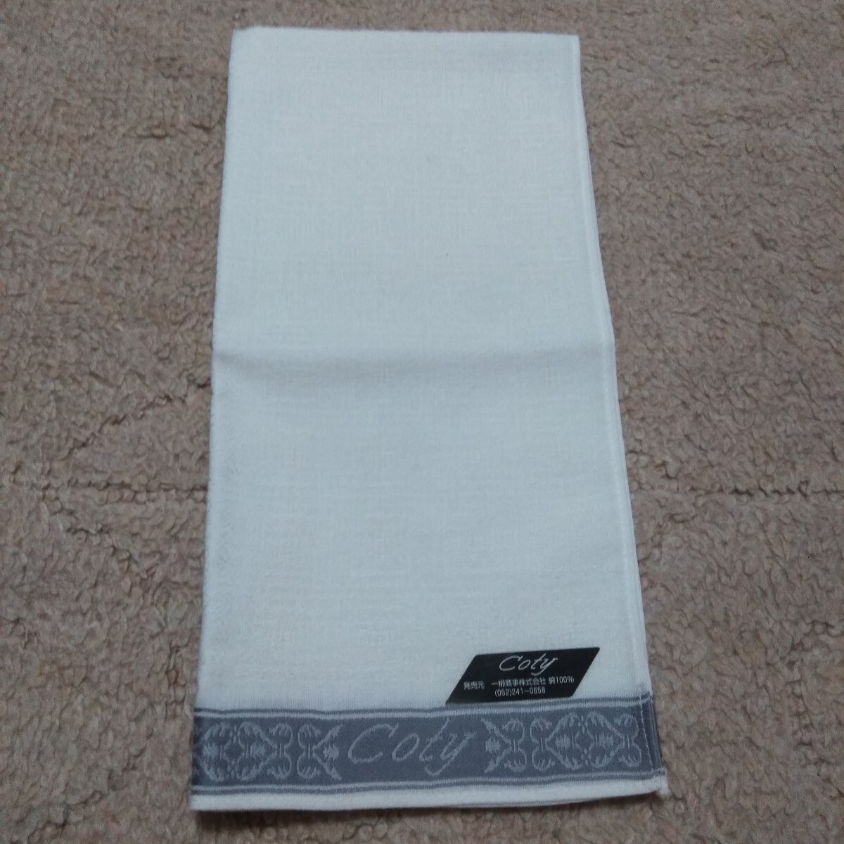【未使用】Coty コティ メンズオフホワイトハンカチ1枚 地模様総柄上下にグレーのゴージャス柄の帯有り。一角ロゴ織り込み。冠婚葬祭等に_画像2