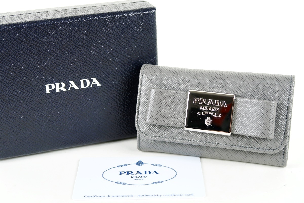 【超美品】PRADA プラダ サフィアーノレザー リボン 6連キーケース グレー 箱付き 小物【JX35】