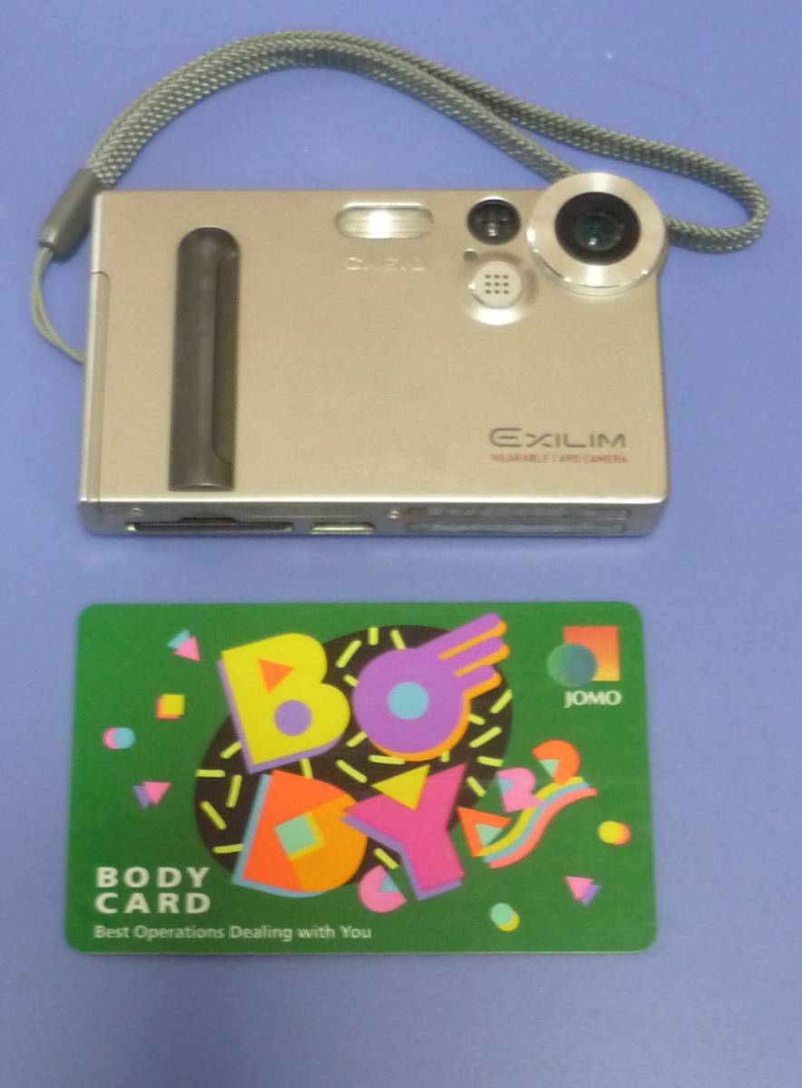 ★カシオ音楽プレーヤー機能付カード・サイズ・デジカメ(ジャンク品):EXILIM WEARABLE CARD CAMERA:クレードル,アプリＣＤ付き、型番不明。_カシオ：カード・サイズ・デジカメ