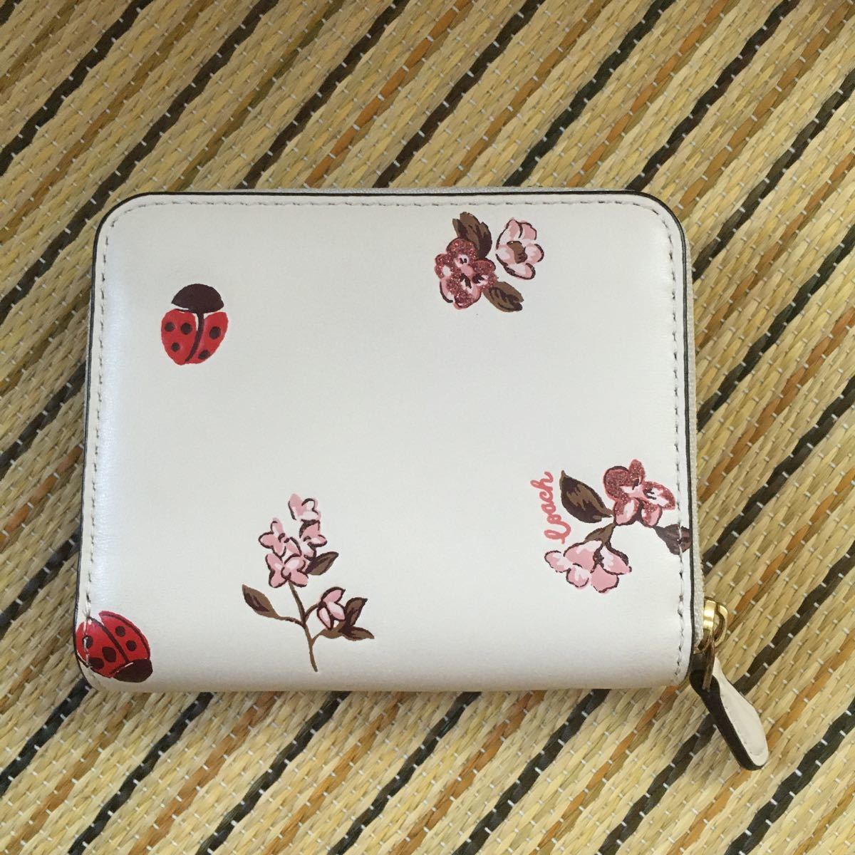 COACHのてんとう虫と花柄の2つ折り財布 holdmeback.com