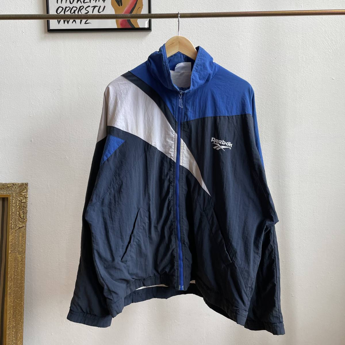 古着 90s Reebok ナイロンジャケット リーボック フロッキーバックプリント SV-ORTSGRUPPE TIENGEN ベクターロゴ ブルー XL C74_画像1