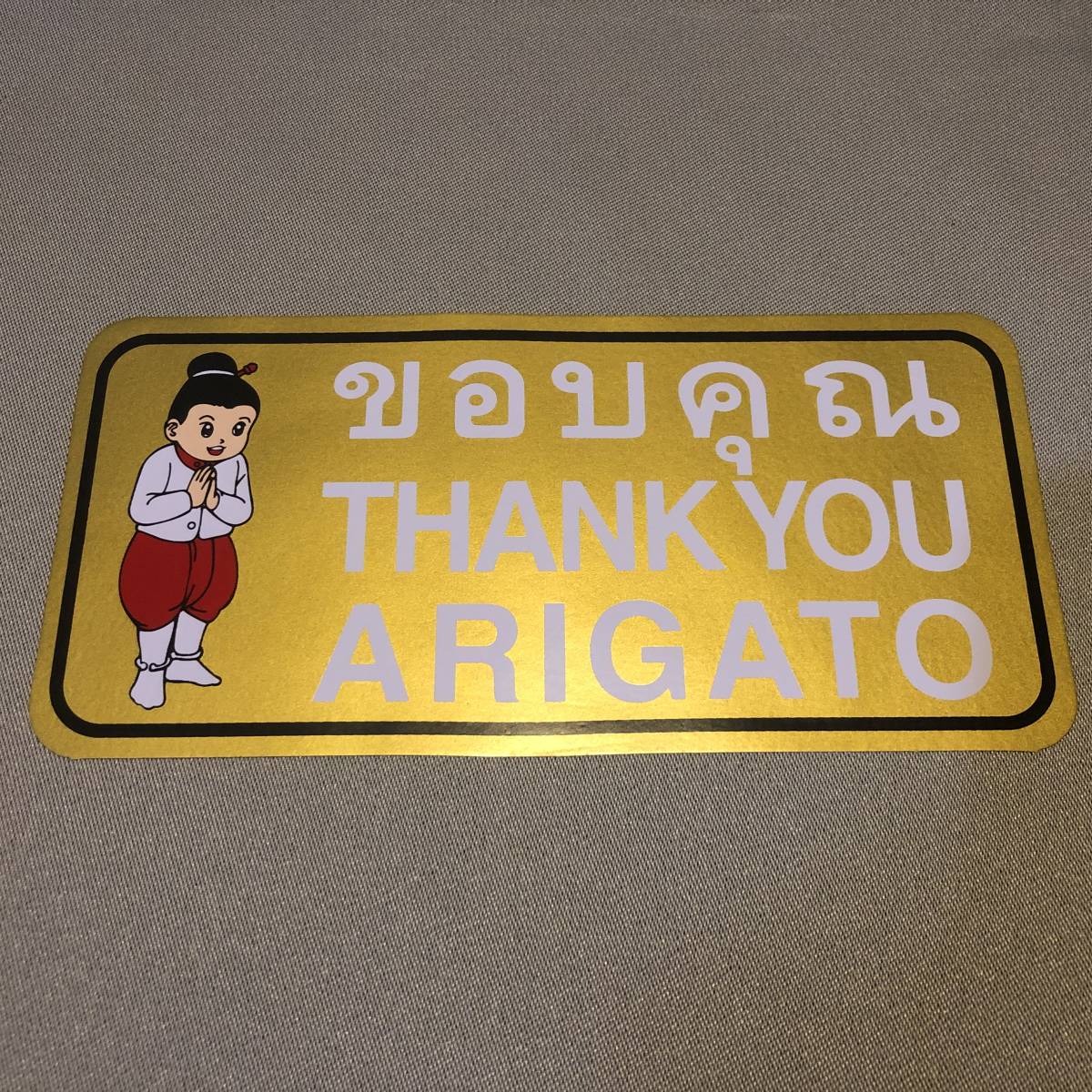 新品・即決・タイで購入した英語、タイ語、日本語ローマ字併記の’THANK YOU・ARIGATO’のステッカー・金色_画像1
