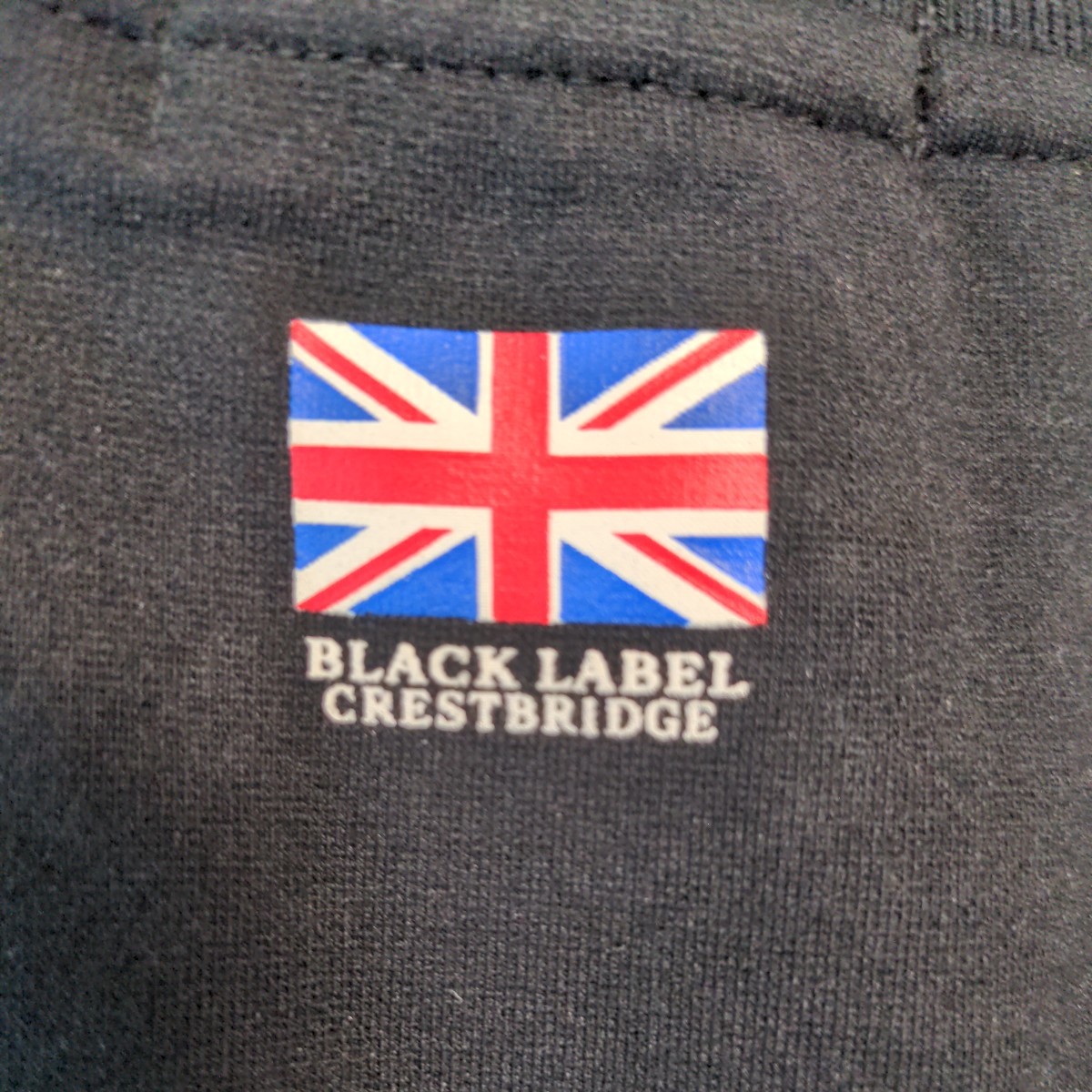【中古美品】BLACKLABEL CRESTBRIDGE ブラックレーベル クレストブリッジ　トラックジャケット　ジッパーラインブルー サイズ3(L) ブラック_背面襟元にユニオンジャック