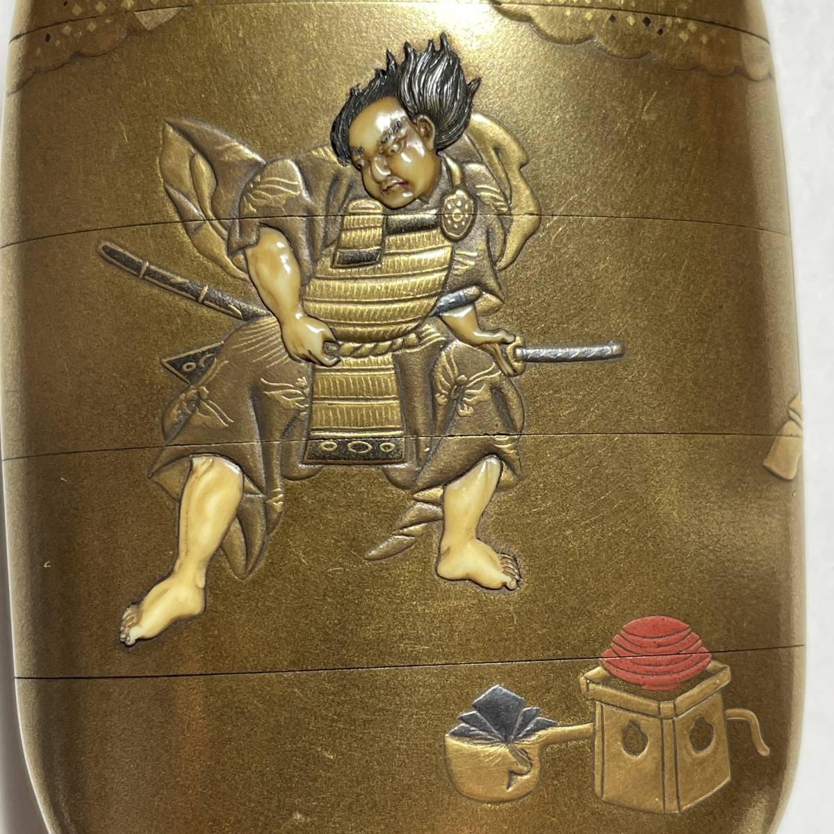 Sản phẩm 【茂蔵】本金地内梨地蒔絵印籠 武将図 四段 金蒔絵饅頭根付