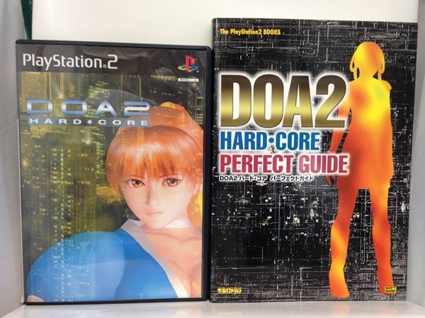 PS2+本『「DOA2 HARD・CORE」＋「DOA2ハード・コア パーフェクトガイド」』送料安*(ゆうメールの場合)_画像1