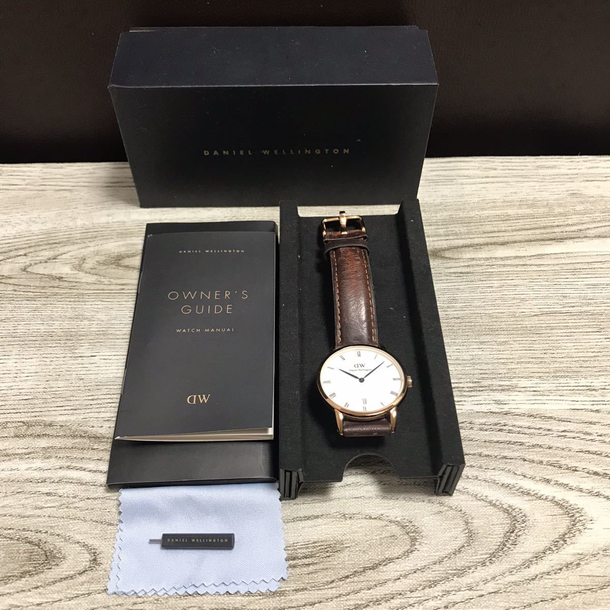 103-0007 Daniel Wellington ダニエルウェリントン B34R5 レディース腕時計 レザーベルト ブラウン 青針 電池切れ 動作未確認_画像1