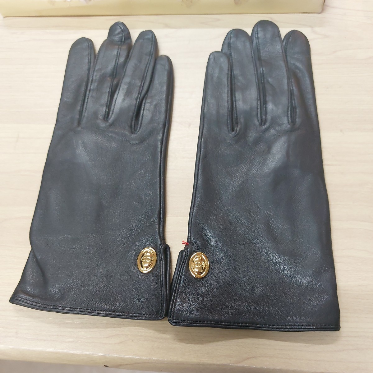 Кожаные кожаные перчатки христианины Dior упаковывают кожу кожу кожа грязной, но рядом с неиспользованными кожаными перчатками черные перчатки