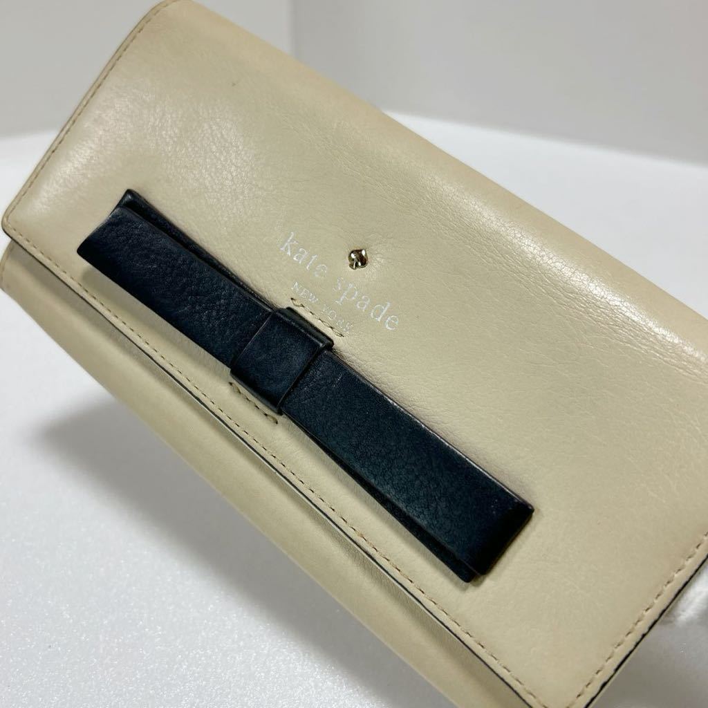 ★kate spade ケイトスペード★　長財布　フラップ式　小銭入れ有　ロゴ刻印　レザー　リボン　ベージュ 【USED】0124A