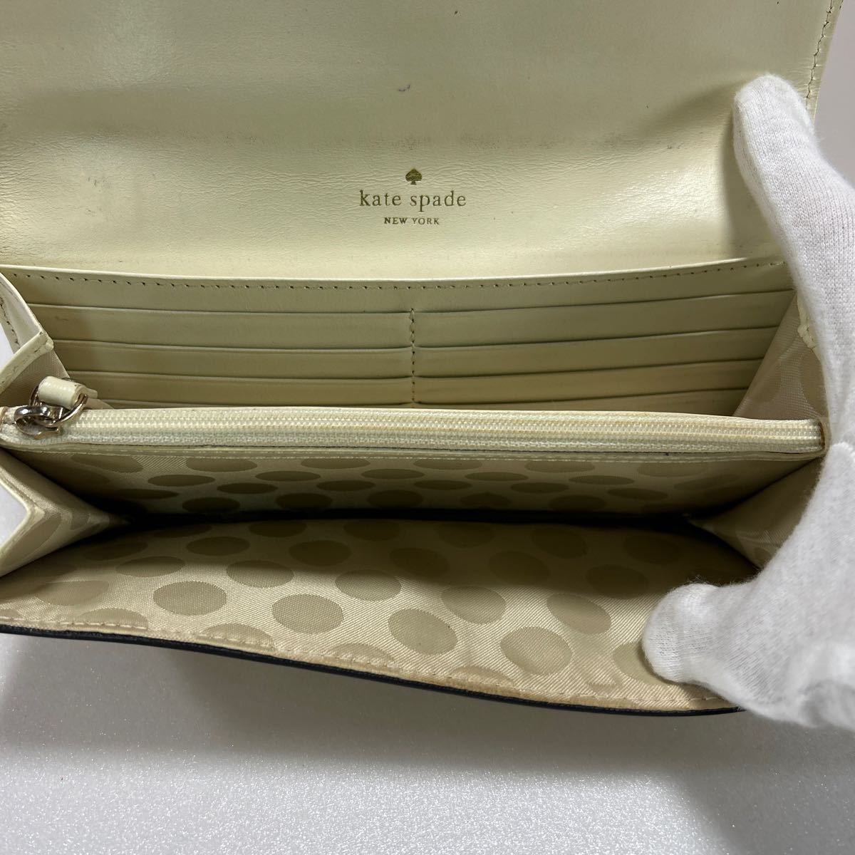 ★kate spade ケイトスペード★　長財布　フラップ式　小銭入れ有　ロゴ刻印　レザー　リボン　ベージュ 【USED】0124A