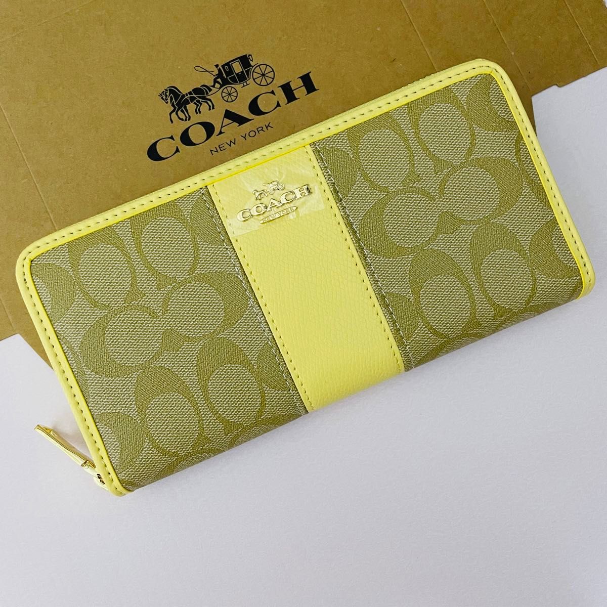 Coachコーチレディース長財布　新品　　ブラウンカラーのシグネチャー柄　レモンカラーライン