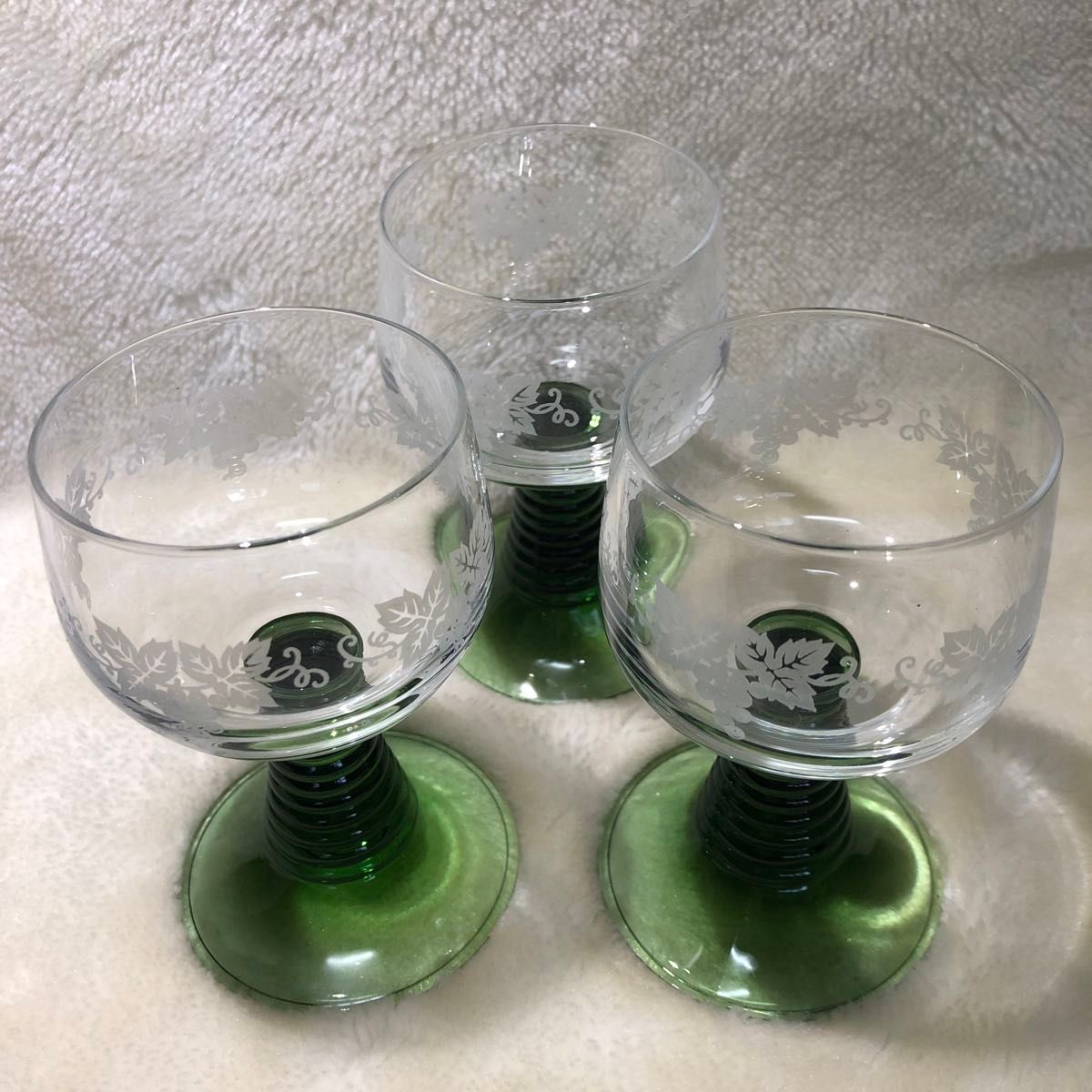 ワイングラス3個　ガラス工芸品。透明ガラスにブドウの絵柄を施術。スタンド部はグリーンで土台の安定感のある逸品。