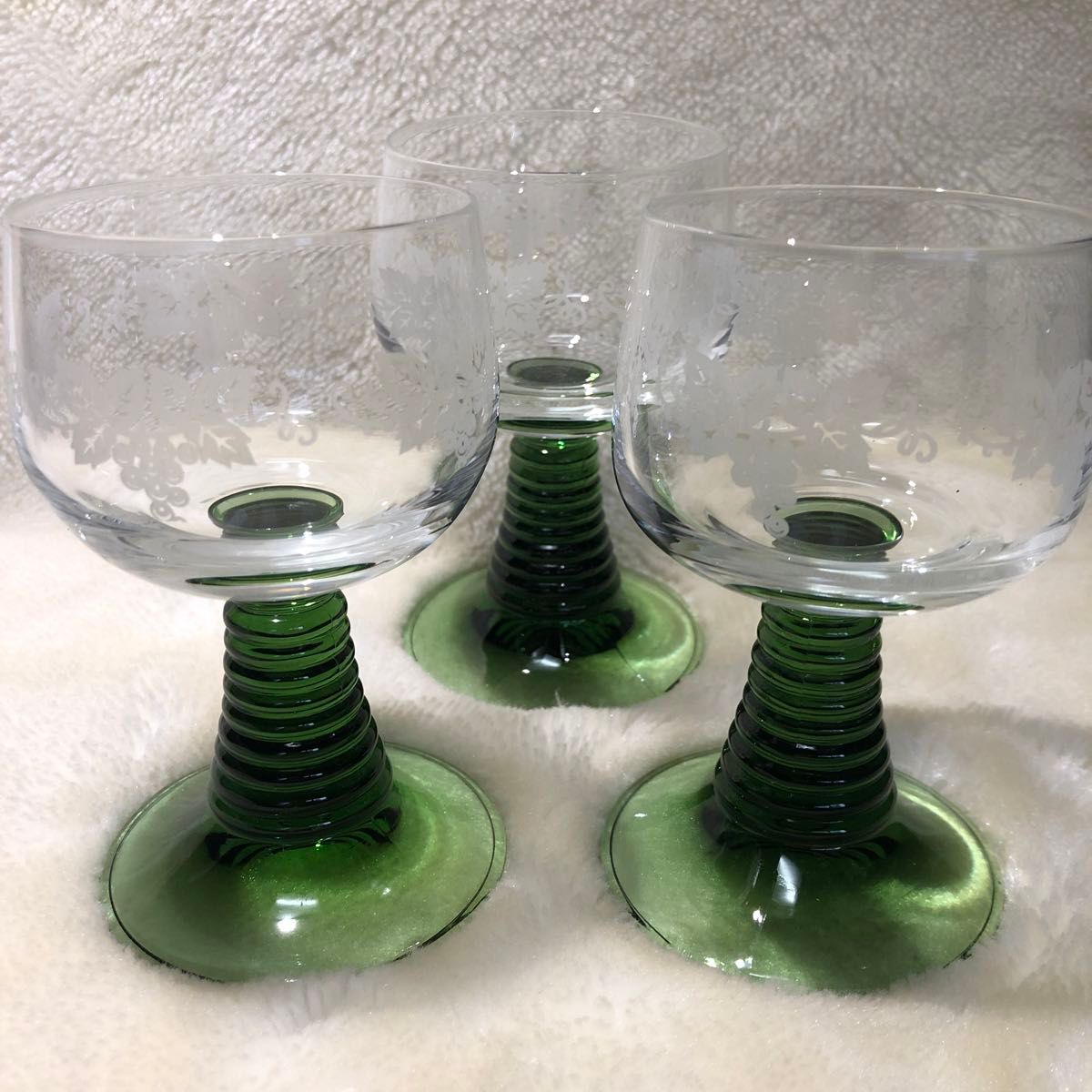 ワイングラス3個　ガラス工芸品。透明ガラスにブドウの絵柄を施術。スタンド部はグリーンで土台の安定感のある逸品。