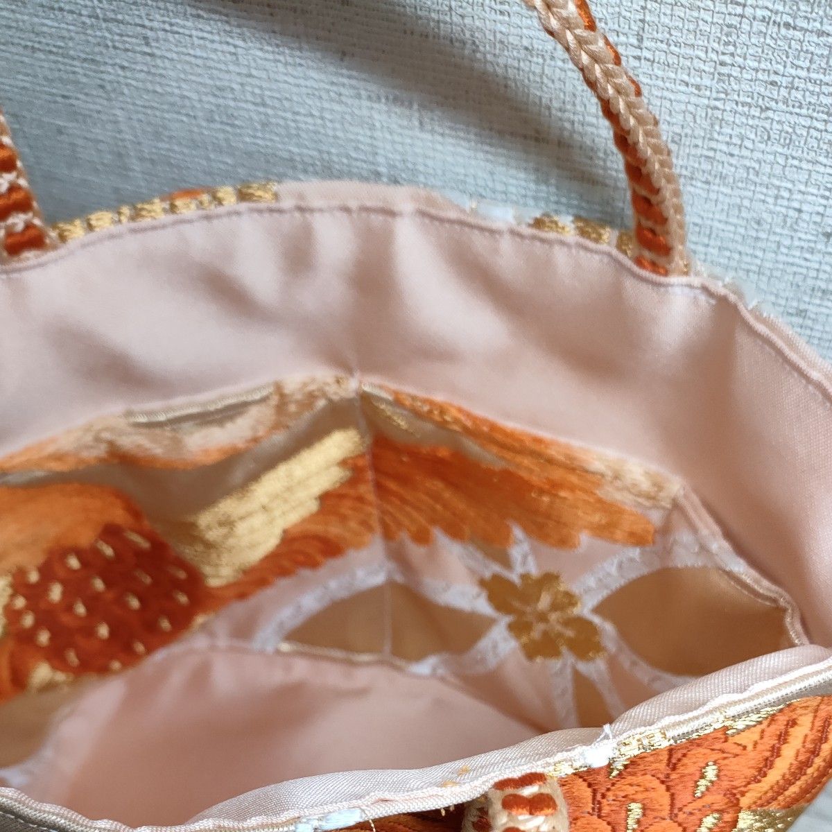 帯バッグ　サーモンピンク色　七宝文様　上下対い鶴菱紋様の刺繍 