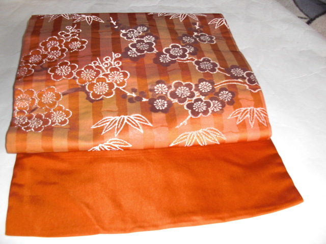 なごやおび　正絹名古屋帯　オレンジの縦縞の地色に可愛らしい梅の花と笹の柄が銀糸で織られたステキな名古屋帯