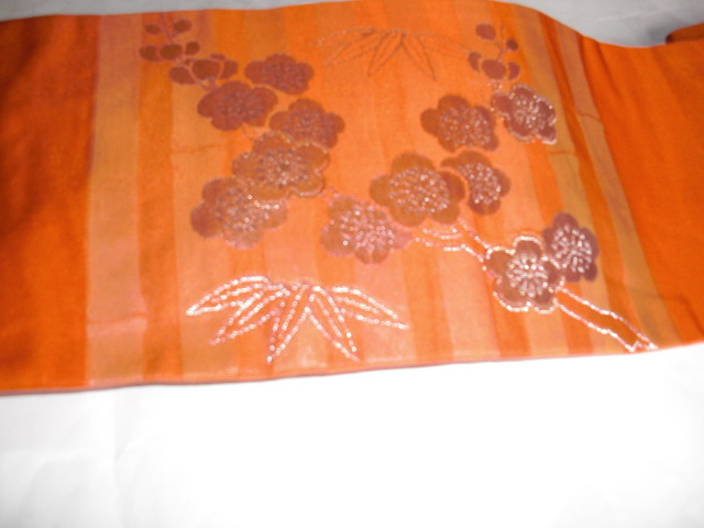 なごやおび　正絹名古屋帯　オレンジの縦縞の地色に可愛らしい梅の花と笹の柄が銀糸で織られたステキな名古屋帯