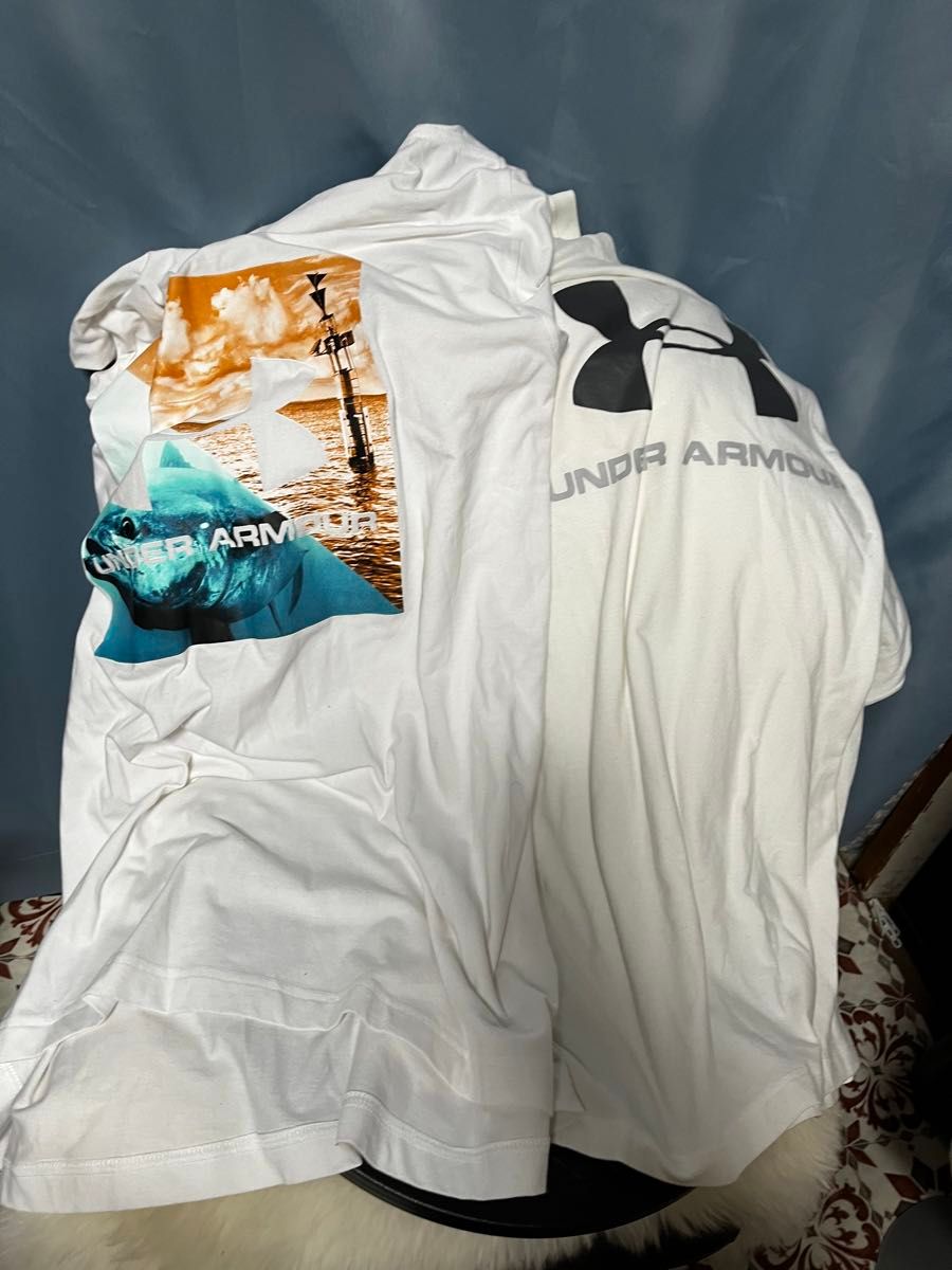 #買い得#アンダーアーマーの白色Tシャツ。胸元の写真には、マグロの写真などおもしろい柄にロゴが鎮座しています。状態は未使用に近い。