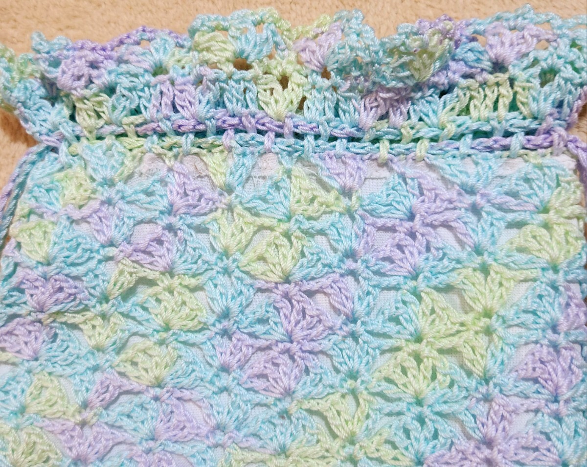 薄水色、薄紫色、薄々緑色のグラデーションレース糸で編ん巾着に可愛いお花のアップリケを付けました。（裏に白色の生地を使いました）_画像2