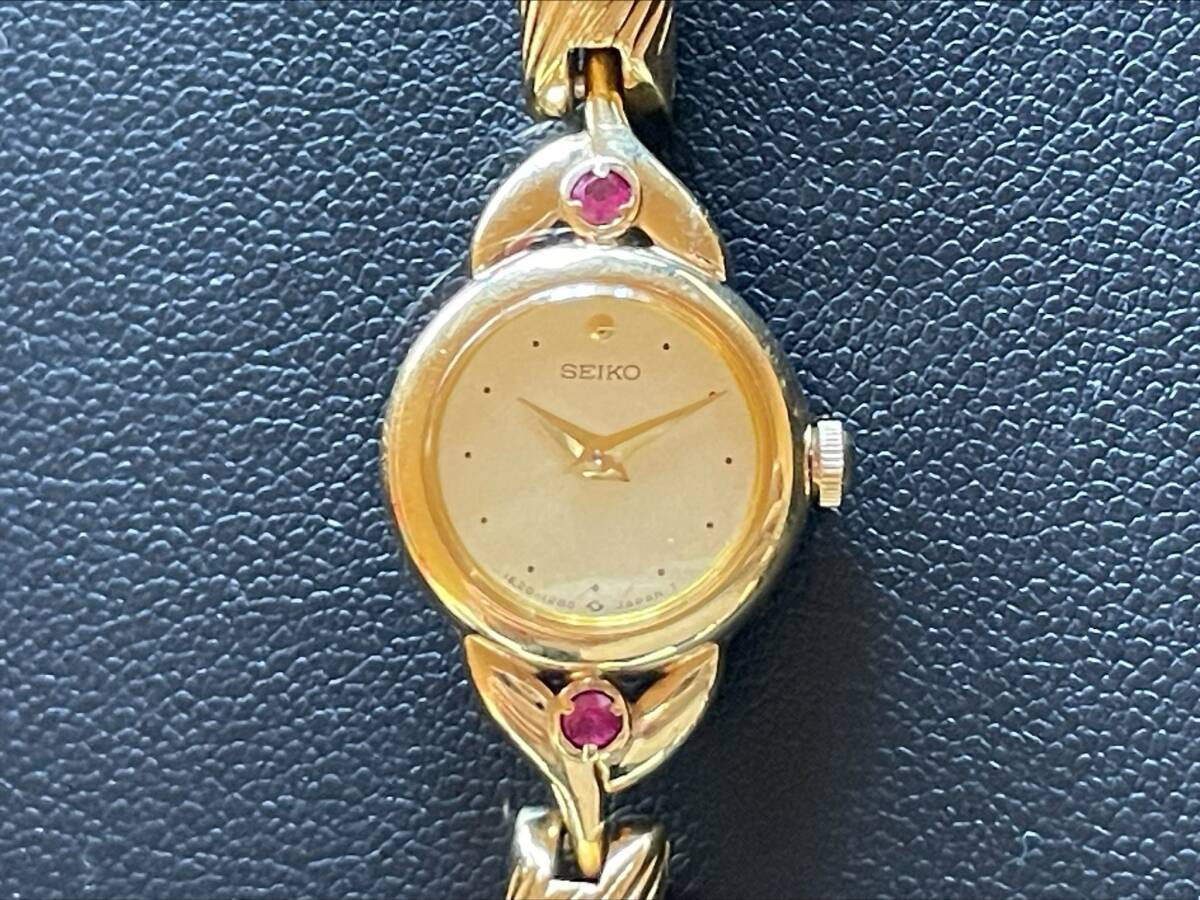 #1556 SEIKO セイコー レディース時計 1E20-0430 クォーツ 文字盤ゴールド 石付き腕時計  の画像1