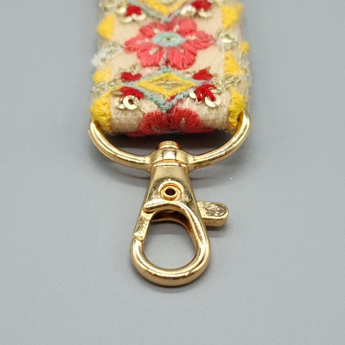 [150]インド刺繍リボンのスマホ用ハンドストラップ（生成り・ピンク系、金具：ゴールド系）、ハンドメイド