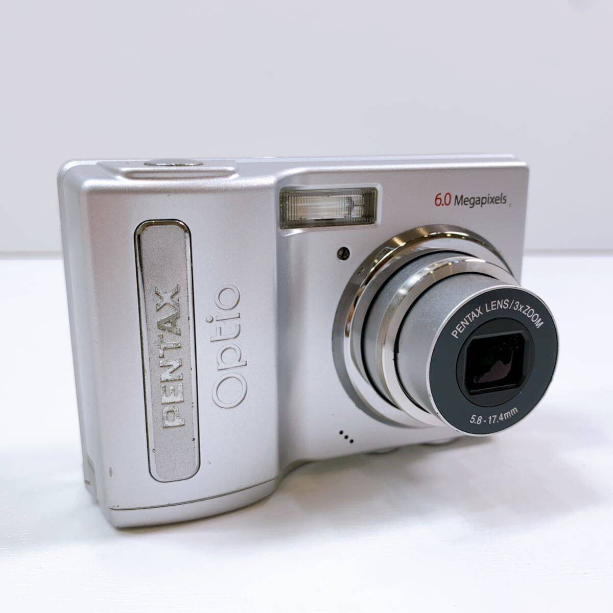 152【中古】PENTAX Optio M10 6.0 PENTAX LENS 3x ZOOM 5.8-17.4mm Megapixels ペンタックス デジカメ シルバー 通電確認済み 現状品 _画像1