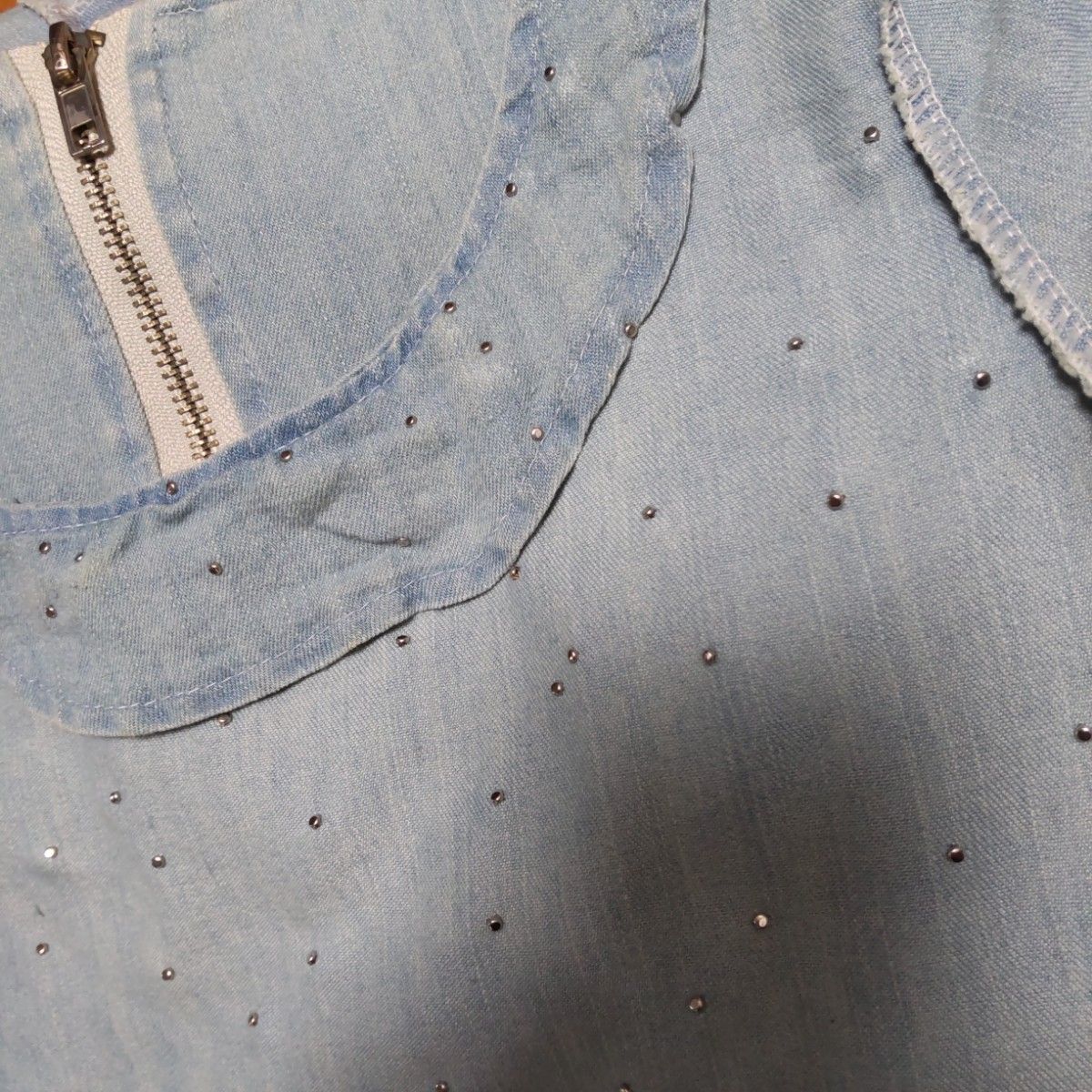ライトブルーのダメージデニム　薄地の柔らかな素材　胸のパールが大人可愛い　両ポケット付き